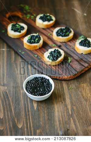 Black caviar over the wooden kitchen table.