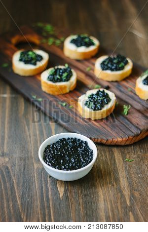 Black caviar over the wooden kitchen table.
