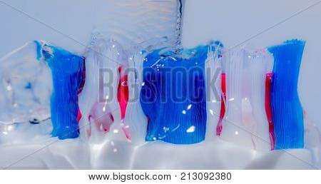 View of colorful tooth brush under water fall.