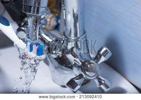 View of colorful tooth brush under water fall.