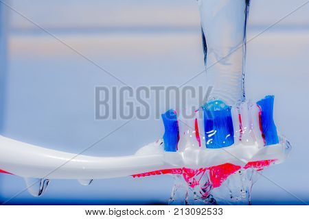 View of colorful tooth brush under water fall.