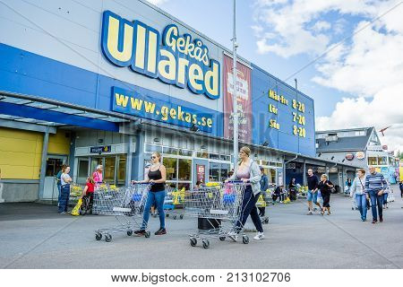 Walking with shopping carts to the entrance of GeKas in Ullared September 3 2017