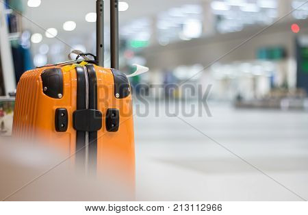Yellow Suitcase safety bag in airport departure travel luggage for holiday vacation at blur airplane terminal waiting area for passenger hall background focus on suitcases.