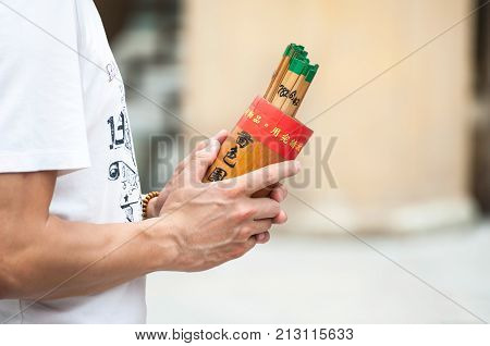 WONG TAI SIN HONG KONG - OCT 27 2013 - Man holds a box of fortune sticks at Wong Tai Sin temple Hong Kong