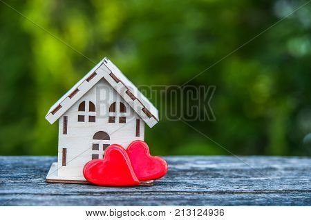 A toy house with a fence of hearts. A symbol of a house where love reigns. Theme of happiness warmth good luck love construction travel hotel business family