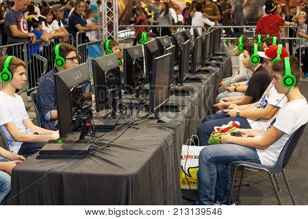 ROME, ITALY. October 03, 2015: Boys tournament players and gaming consoles. Row of young boys playing with a console. Wearing headphones. Romics 2015 in Rome, Italy. Festival of comics and gaming.
