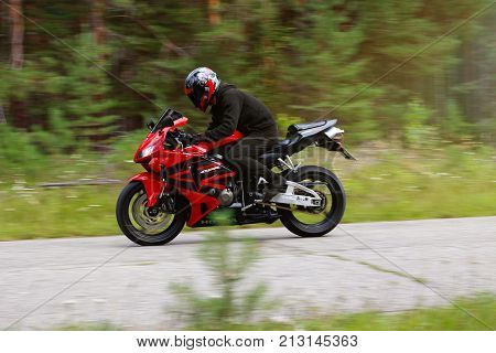 Krasnoyarsk, Russia - August 09, 2017: A Motorcyclist Wearing A Helmet With A Black Visor And Red Sp