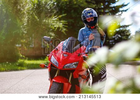 Krasnoyarsk, Russia - August 09, 2017: A Girl Motorcyclist Wearing A Helmet And Red Sport Bike Honda