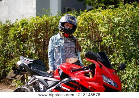 Krasnoyarsk, Russia - August 09, 2017: A Girl Motorcyclist Wearing A Helmet And Red Sport Bike Honda