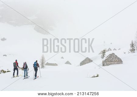 Group of skiers exploring ruins of Great war buildings. Komna, Slovenia.
