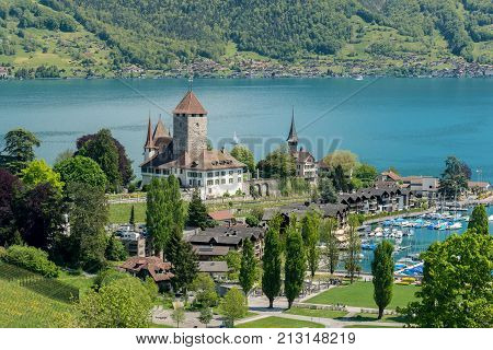 Spiez castle with sailboat on lake Thun in Bern Switzerland.