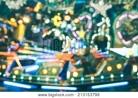 Blurred defocused bokeh lights at Christmas luna park carousel roundabout - Winter market festive concept having fun around the world - Fun games and funfair fantasy background - Vintage filter
