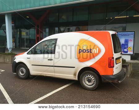Muiden, The Netherlands - November 11, 2017:  PostNL delivery van parked in a public parking lot. PostNL (Post.nl) is a large mail, parcel company  operating in the Netherlands, Germany and UK.