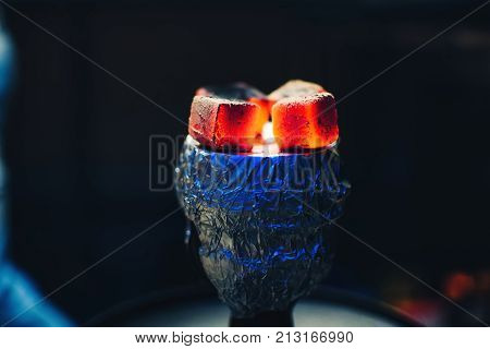 coals of the Shisha on the foil on the bowl with tobacco Smoking and red hot
