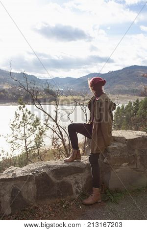 Girl Hipster Sits On The Background Of Mountains