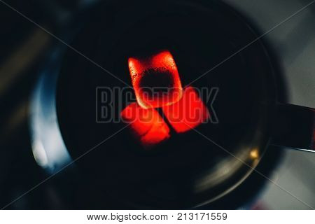 hot coals for Shisha bowl tobacco Smoking and relaxation closeup on dark background