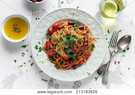 Vegetarian Italian Pasta Alla Puttanesca with garlic, olives, capers with on white plate