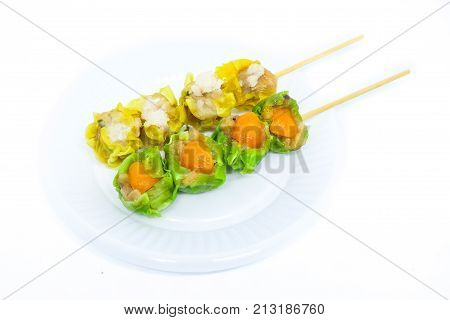 Close up yellow crab-filled & green salted egg pork-filled chinese steamed dumpling or dim sum serve on white plastic dish isolated on white background - food chinese concept.