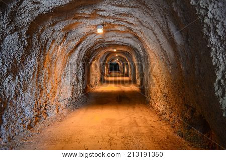An old illuminated underground tunnel stretching into the darkness.