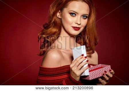 Happy woman in excitement opening Christmas box 