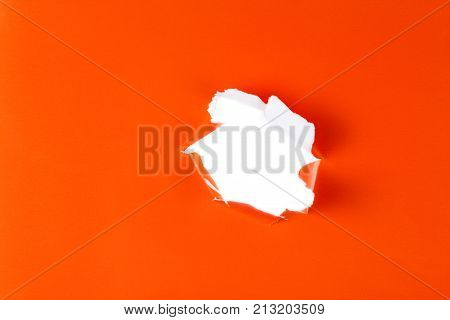 Torn Orange Paper Hole. Tearing Inside White