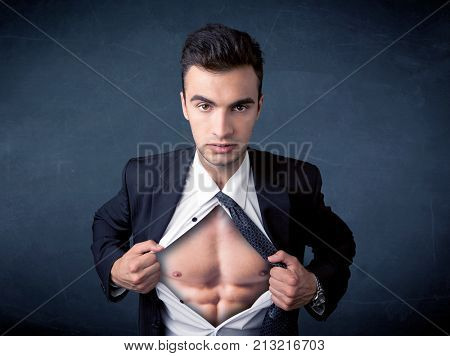 Businessman tearing off his shirt and showing mucular body concept on background