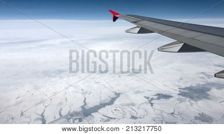View Of Airplane Wing Abowe The Clouds And Land