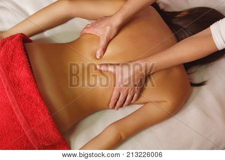 Spa treatment. Back massage. Massage zone of the widest mice of the back. Moistening with oil. Restorative procedures