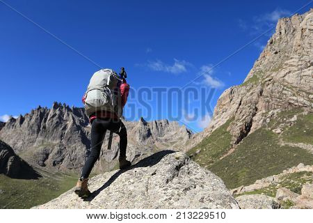 woman with backpack hiking in mountains travel lfestyle success concept