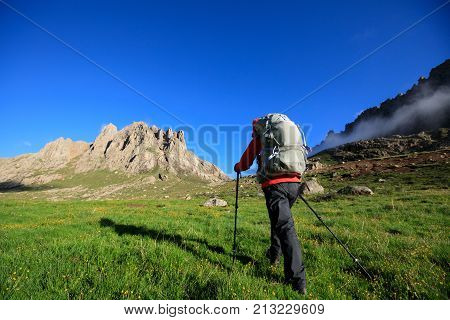 woman with backpack hiking in mountains travel lifestyle concept adventure active vacations outdoor mountaineering sports landscape