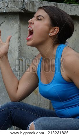 Female Teenager And Anger Wearing a Blue Shirt
