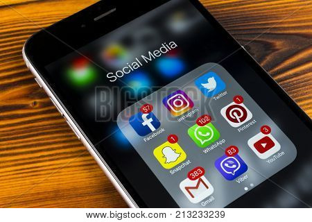 Sankt-Petersburg Russia November 11 2017: Apple iPhone 7 plus on wooden table with icons of social media facebook instagram twitter snapchat application on screen. Smartphone Starting social media app.