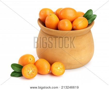 Cumquat or kumquat with leaf in wooden bowl isolated on white background close up.