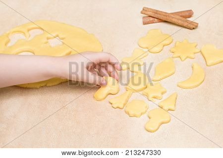 Children's hands make christmas cookies. Children's hands holding cookies of raw dough for christmas