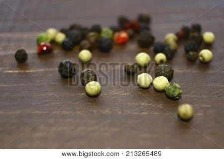 Different Kinds Of Pepper Are Scattered On The Table.