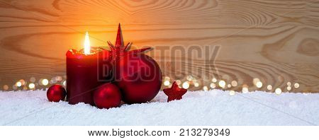 Avent candle and christmas decoration isolated on wood background. Christmas background with snow, candle and red star.