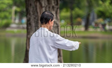 Man Exercising By Tai Chi In A Outdoor Park