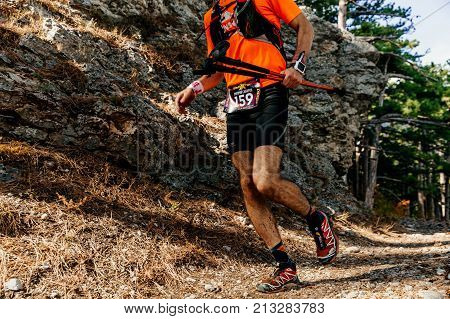 Crimea Russia - October 13 2017: man athlete runner with trekking poles running forest trail during Crimea Х Run