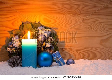 Avent candle and christmas decoration isolated on wood background. Christmas background with snow, candle and wood fir tree.