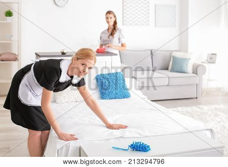 Beautiful chambermaids cleaning room