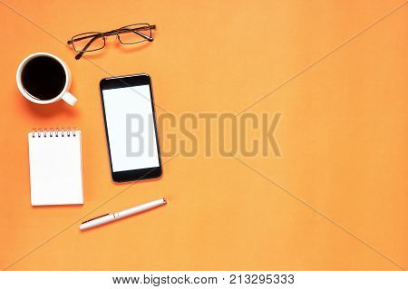 Top view Modern workplace with notbook and pen with smart phone placed on white background. Copy space suitable for use in graphics.