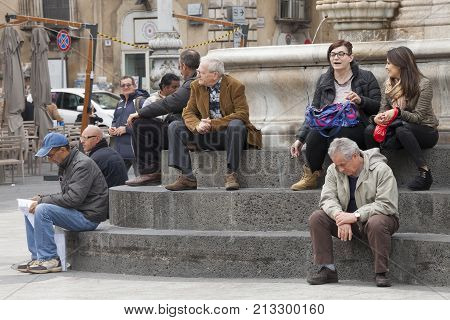 CATANIA, ITALY. April 03, 2015: Piazza del Duomo main city square in Catania, Sicily. Italy. Obelisk with elephant (Symbol of the city). On the steps of the monument many people, citizens and tourists