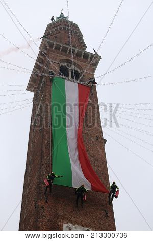 Vicenza, Vi, Italy - December 4, 2015: Firefighters With A Big Italian Flag And The Tower Of Ancient