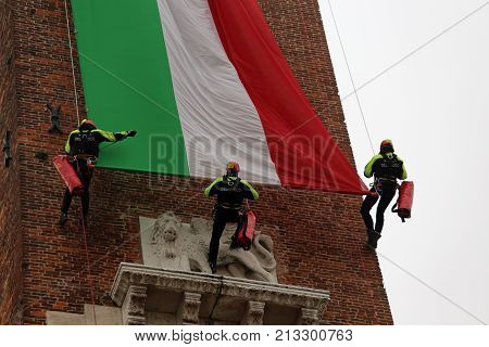 Vicenza, Vi, Italy - December 4, 2015: Firefighters With A Big Italian Flag And The Tower Of Ancient