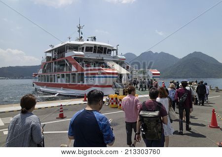 Hiroshima, Japan -  May 26, 2017: Tourists embark on the ferry at port Miyajimaguchi to travel to Miyajima island