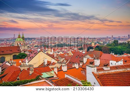 Prague area Mala Strana and St. Mikulas Cathedral in the evening at sunset in autumn. A lot of red tiled roofs. Czech Republic