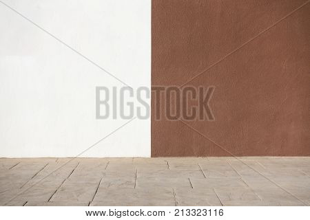 City street background. White and brown plastered wall and sidewalk pavement