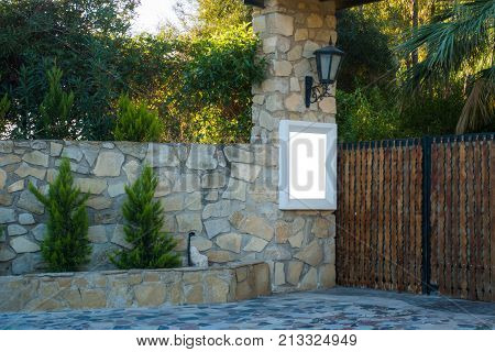 Mock up near the gate to the private house yard. Wooden gates and a high stone fence.