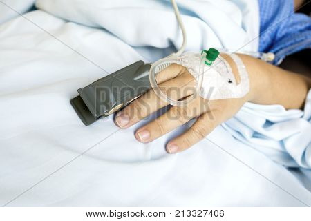 Pulse Sensor and Iv Drip on Patient Hands at the Hospital Room.