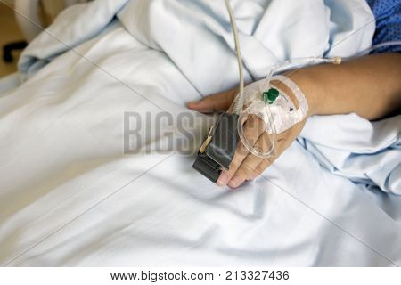 Pulse Sensor and Iv Drip on Patient Hands at the Hospital Room.